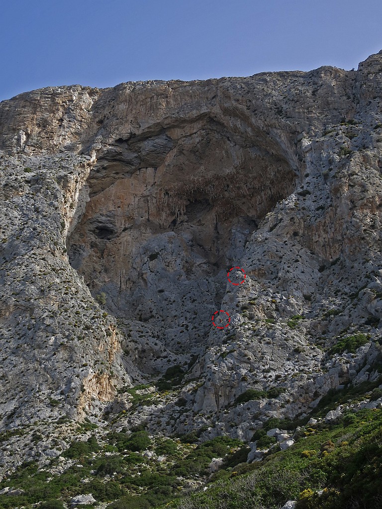 IMG_0404.JPG - La via percorre l'evidente spigolo sulla destra della grotta. Ben visibili due arrampicatori nei cerchi rossi. Guardando la parete sembra impossibile che le difficoltà siano così basse ma in relatà la roccia è appigliatissima oltre che molto solida. Una descrizione accurata si trova qui http://www.scuolafrancoalletto.it/scuola/attachments/article/97/VIA%20WING%20FOR%20LIFE%20TELENDOS%20KALYMNOS%20GRECIA.pdf  Aggiungo solo che è possibile farsi portare in prossimità dell'attacco dallo stesso barcaiolo che fa il tragitto Kalymnos / Telendos ogni mezz'ora risparmiazndo così un'ora a piedi. 